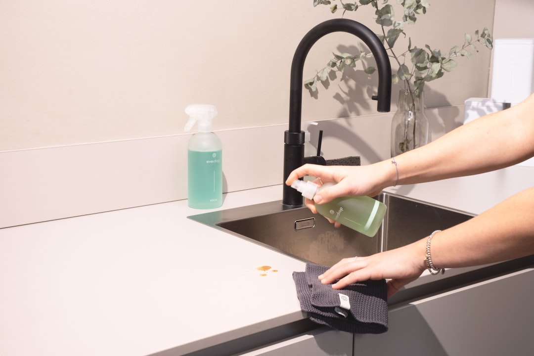 services-02 a-woman-is-cleaning-a-kitchen-sink-with-a-rag-sqomdoqb3ws